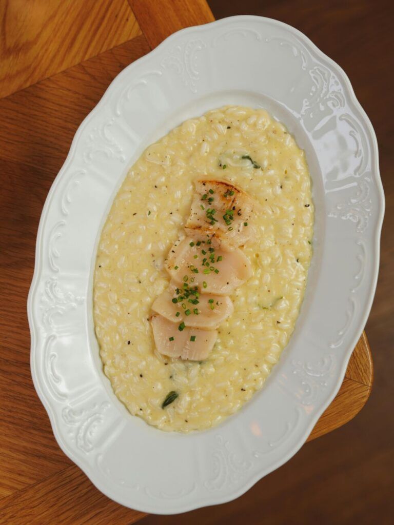 Close-up of delicious risotto with scallops elegantly plated, perfect for gourmet dining.