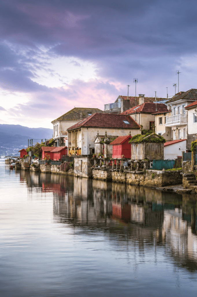 Casas marineras y hórreos tradicionales de Combarro reflejados en la ría al atardecer, en uno de los pueblos más bonitos de las Rías Baixas.