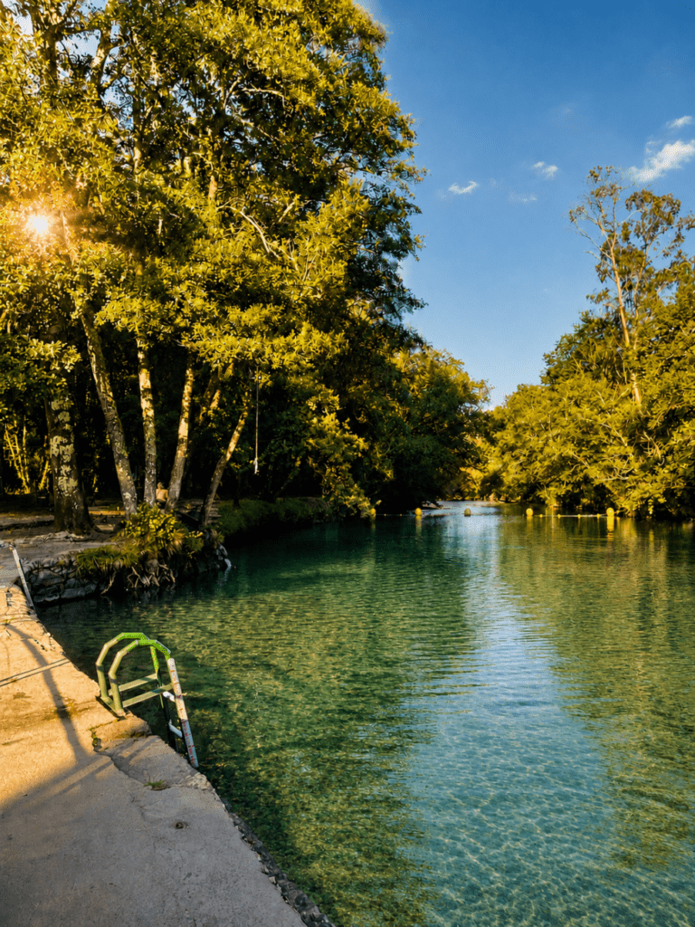 Río Verdugo en Ponte Caldelas con aguas cristalinas y transparentes rodeadas de bosque frondoso en un día soleado de verano en Galicia.
