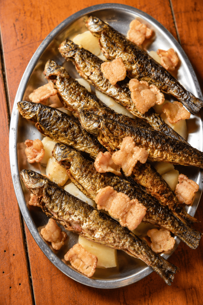 Plato tradicional de truchas fritas de Ponte Caldelas servido en Restaurante Casa Pipeiro, acompañado de patatas y torreznos.