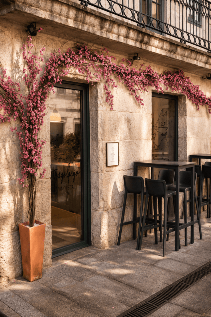 Fachada de TRAGOLARGO en Ponte Caldelas, con terraza exterior, piedra gallega y decoración floral junto al río Verdugo.