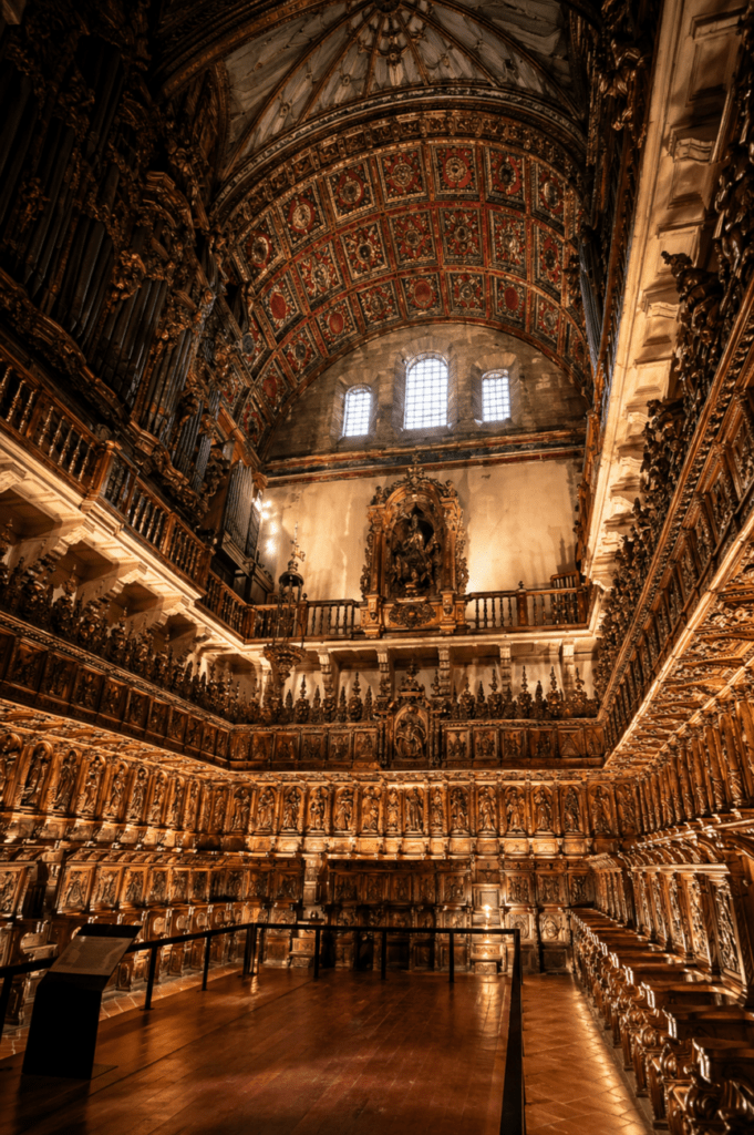 Interior del coro de San Martiño Pinario en Santiago de Compostela, con la impresionante sillería barroca tallada en madera, órgano histórico y bóveda decorada.